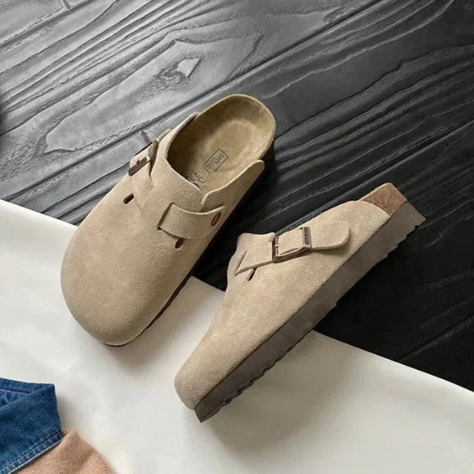 beige-suede-gesp-sandalen-op-houtenvloer.webp